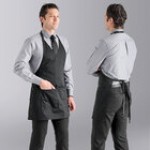 Uncommon Chef 3041 Black Customizable Poly-Cotton Twill V-Neck Tuxedo Apron with Adjustable Neck Strap and 2 Pockets - 28